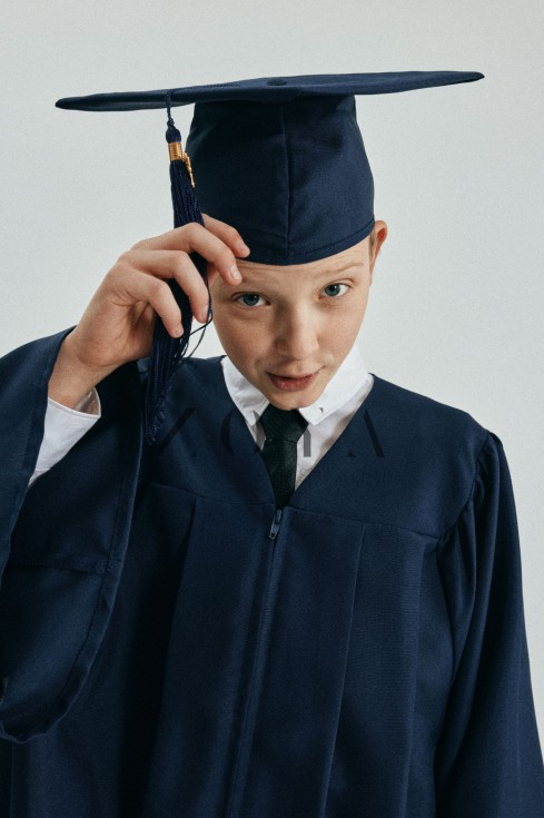 Navy graduation gown on young scholar in Dublin ceremony – elegant navy fabric with golden tassel cap