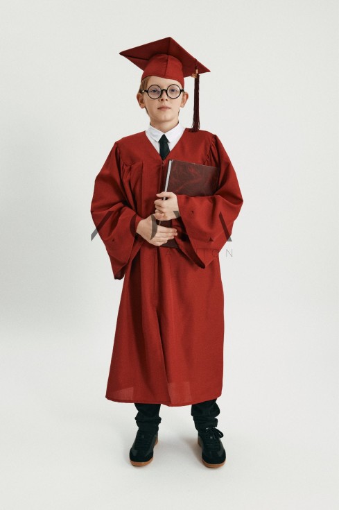 Graduate in crimson cap with 2026 tassel against Irish landscape