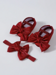 Close-up of red infant bow headband in satin-velvet finish on neutral background