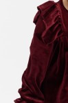 Close up of velour fabric and shoulder ruffles in rich burgundy