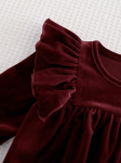 Close up of velour fabric and shoulder ruffles in rich burgundy
