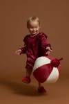 Girl wearing burgundy velour party dress with ruffle shoulders