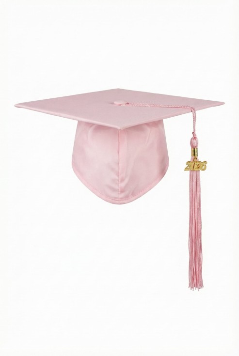 Blush pink children’s graduation cap with golden 2026 charm on white background