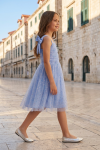 Rina light cornflower blue dress for girls – girl on an old town street, full-length profile