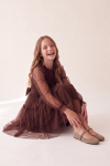 Holly chocolate brown dress for girls with tulle skirt and bow at the waist – seated pose