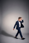 Sam navy suit for boys with black bow tie – boy in motion, open blazer, full length