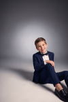 Sam navy suit for boys with black bow tie – boy sitting on the floor, front view