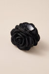 Black fabric flower claw clip for girls on a beige background – three-quarter view