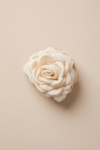 Beige flower claw clip for girls – fabric rose seen from above on a beige background