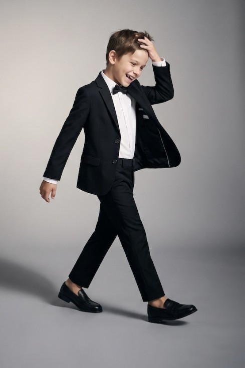 Sam black suit for boys with blazer, trousers and bow tie – boy in motion, open blazer, full length