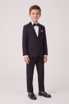 Sam black suit for boys – two-button blazer, creased trousers and bow tie, boy facing the camera